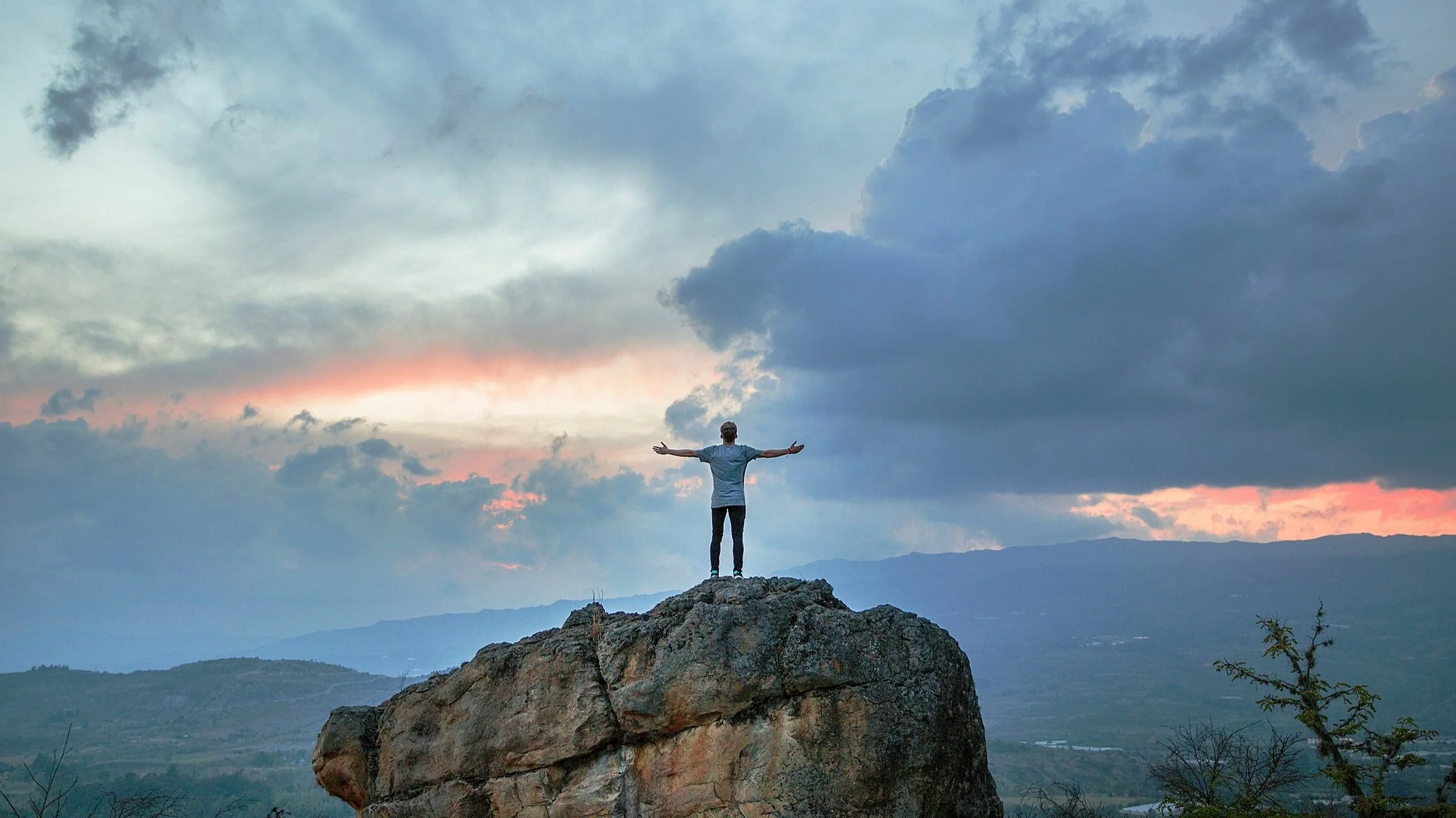 Person on a mountain, arms open